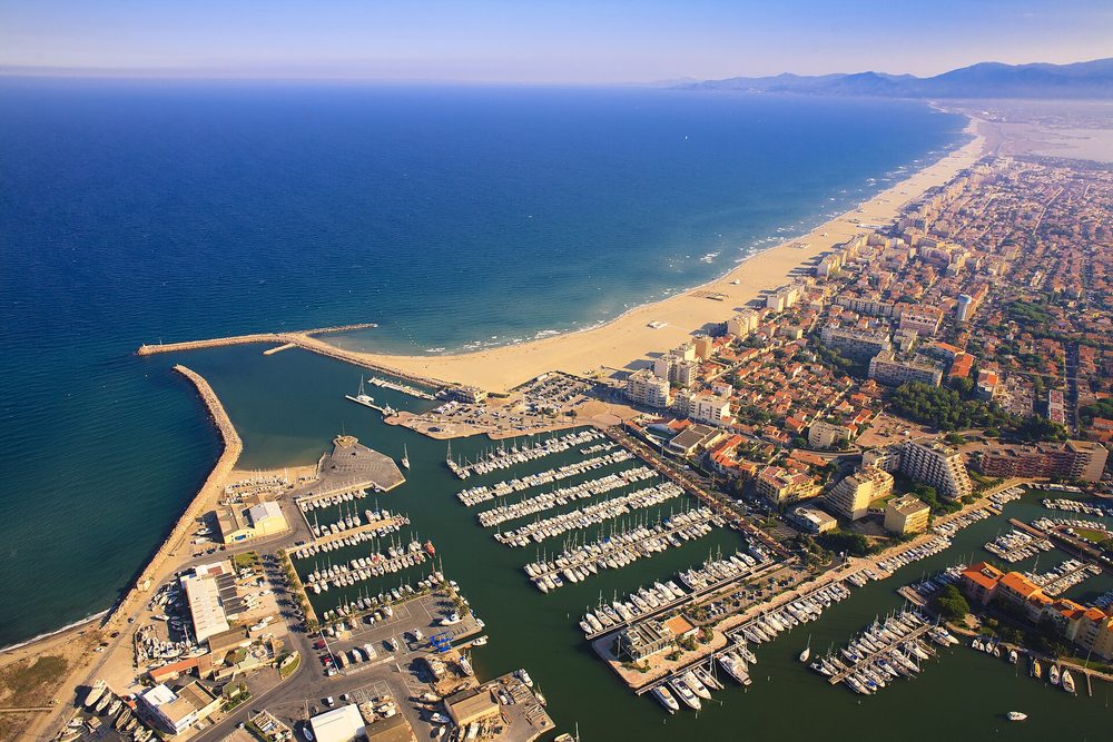 Vue aérienne du port et de la plage de Canet-en-Roussillon, où saisonniers et professionnels du tourisme gèrent un fort volume de réservations