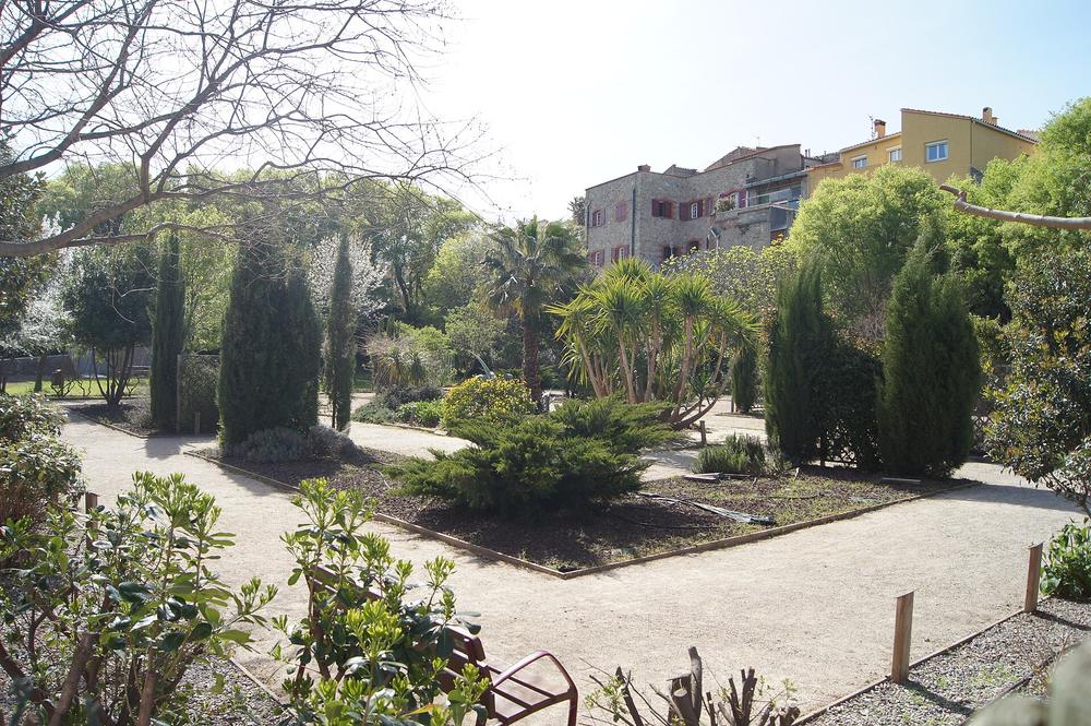Jardin public arboré du Boulou, avec une bâtisse en pierre en fond